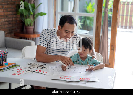 Portrait von asiatischen Kleinkind studieren mit ihrem Vater zu Hause. Stockfoto