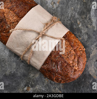 Flach still life ein Laib Mischkornbrot auf Schiefer Hintergrund. Stockfoto