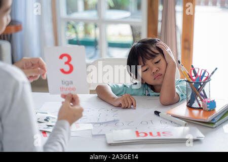 Müde und Kleinkind gelangweilt während des Studiums mit der Mutter zu Hause Stockfoto