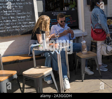 Der Mann und die Frau saß am Tisch mit Flasche und Gläser, die Getränke der Stadt Cambridge 2019 Stockfoto