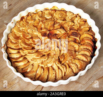 Hausgemachten Apfelkuchen - Charlotte. auf weißer Keramik Platte auf Holz- Hintergrund mit frischen Äpfeln. Selektive Weichzeichner. Text kopieren. Herbst, mir bei Erntebeginn Hilfestellung Stockfoto