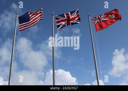 Amerikanischen, britischen und Bermudian Flaggen über Royal Naval Dockyard, Bermuda fliegen Stockfoto