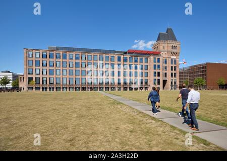 Frankreich, Nord, Lille, Bezirk von Bois Blancs, EuraTechnologies business park Pole der Exzellenz der TIC der Lille Metropole, die sich in der Blan Lafont, ist eine alte Spinnerei im Jahre 1900 erbaut, drei Männer und eine Frau aus zu Fuß zurück auf den Weg zum Hauptgebäude gesehen Stockfoto