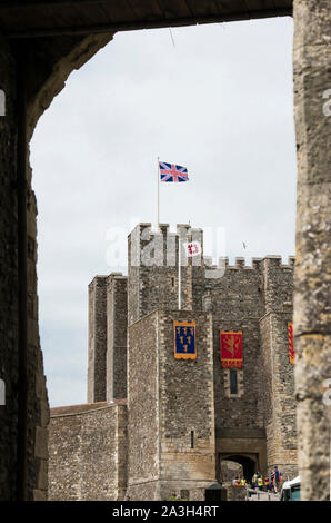 White bird über Union Jack flag Pole zu Land, Flagge an einem sonnigen Tag über Dover Castle, Kent England fliegen. Auf dem Dach des Schlosses crenelations Halten. Stockfoto