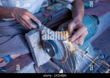 China, Xinjiang autonome Region, Yengisar, Workshops, die traditionellen Uigurischen Dolche und Messer, Schärfen der Klingen auf einer Schleifscheibe Stockfoto