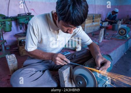 China, Xinjiang autonome Region, Yengisar, Workshops, die traditionellen Uigurischen Dolche und Messer, Schärfen der Klingen auf einer Schleifscheibe Stockfoto