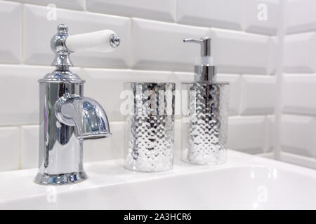Seifen- und Shampoospender in der Nähe von keramischen Wasser Waschbecken mit Wasserhahn in teuren loft Bad tippen Stockfoto