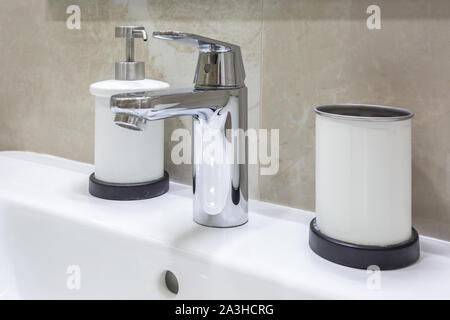 Seifen- und Shampoospender in der Nähe von keramischen Wasser Waschbecken mit Wasserhahn in teuren loft Bad tippen Stockfoto