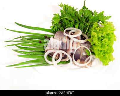 Gesalzene Heringe Fisch mit Zwiebeln, Kräutern, Gewürzen auf weißem Hintergrund Stockfoto