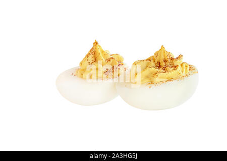 Zwei deviled egg Hälften bestreut mit Paprika und isoliert auf einem weißen Hintergrund. Beschneidungspfad enthalten. Stockfoto