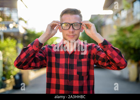 Junge Mann in rot kariertem Hemd in den Straßen im Außenbereich Stockfoto