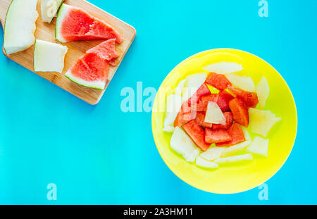 Gesundes Dessert für einen Sommer Picknick mit frische Melone und Keile saftige Wassermelone von oben in einem flachen lag noch leben, blauer Hintergrund gesehen Stockfoto