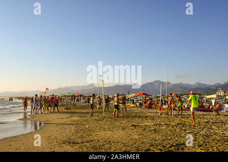 Blick auf den Strand von Lido di Camaiore mit Urlauber spielen Verbände und Beachvolleyball an einem sonnigen Tag im August, Versilia, Toskana, Italien Stockfoto