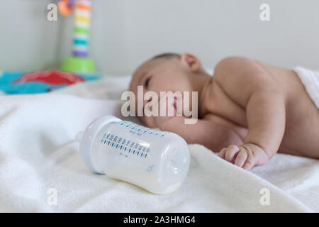 Happy 4 Monate baby boy Kriechen mit Kauen seine Finger auf Bett Stockfoto