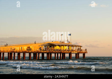 Blick auf pontile Bellavista Vittoria, ein modernes Pier in 2008 gebaut, mit Touristen genießen den Sonnenuntergang im August, Lido di Camaiore, Toskana, Italien Stockfoto