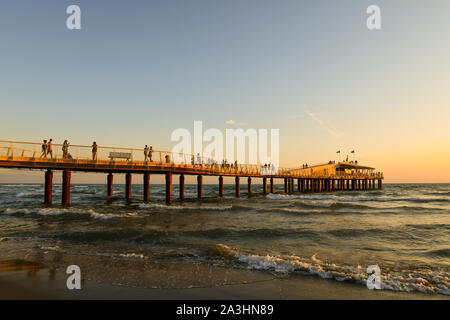 Blick auf pontile Bellavista Vittoria, ein modernes Pier in 2008 gebaut, mit Touristen zu Fuß bei Sonnenuntergang im Sommer, Lido di Camaiore, Toskana, Versilia, Italien Stockfoto