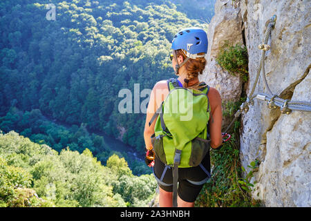 Frau auf Klettersteig Vadu Crisului, Rumänien, bewundern Sie die Aussicht in Richtung Crisul Repede Flusses und den umliegenden Wald. Stockfoto