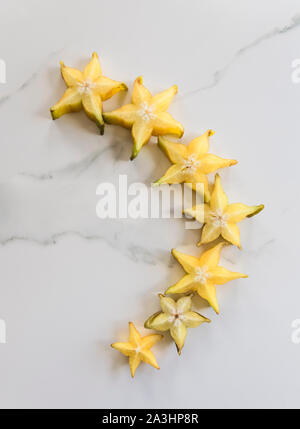 Scheiben von Star Fruit, Karambolen, auf weißem Hintergrund angeordnet. Stockfoto