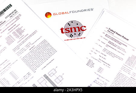 GLOBAL FOUNDRIES vs TSMC. Logos der Unternehmen der Halbleiterindustrie und zwei gedruckte US-Patente, die in Anspruch genommen werden von TSMC verletzt zu werden. Stockfoto