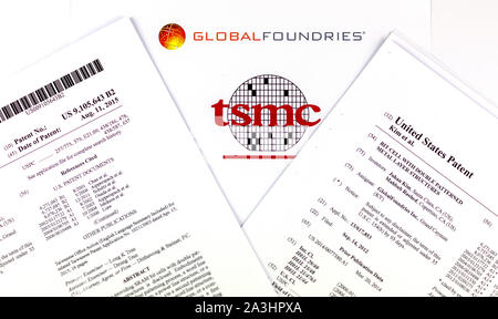 GLOBAL FOUNDRIES vs TSMC. Logos der Unternehmen der Halbleiterindustrie und zwei gedruckte US-Patente, die in Anspruch genommen werden von TSMC verletzt zu werden. Stockfoto