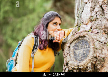 Junge Frau wandern und relaxen auf einem Baum Stockfoto