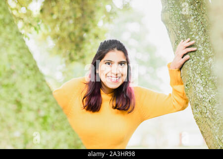 Junge Frau zwischen Bäumen Stockfoto