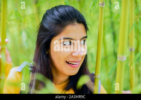 Junge Frau zwischen Bambus Stockfoto