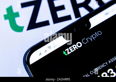 TZero Logos auf die Broschüre und das Smartphone mit dem tZERO Crypto App Screenshot. Stockfoto