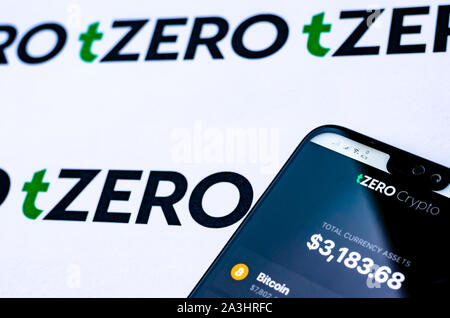 TZero Logos auf die Broschüre und das Smartphone mit dem tZERO Crypto App Screenshot. Editorial Foto zur Illustration auf Nachrichten über eine neue crypto Wallet. Stockfoto
