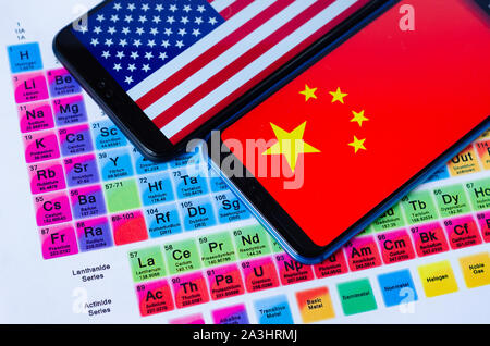 Das Foto von USA und China Flaggen auf Huawei smartphones, die Verlegung auf dem Periodensystem um die Gruppen der seltenen Erden sind. Konzeptionell. Stockfoto