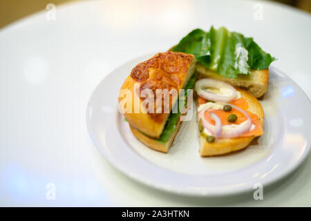 Bagel mit Lachs und Gemüse serviert am Tisch Stockfoto