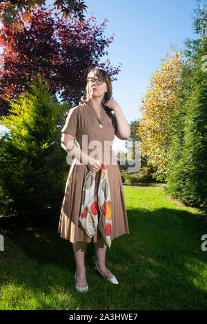 Kartenlänge Portrait von Mid-Adult Frau in Kleid Holding Schal Outdoor Stockfoto