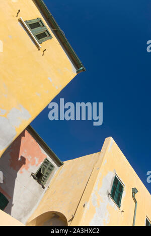 Nahaufnahme der gelben Häuser in Ligurien gegen den blauen Himmel. Alassio ist ein kleines Dorf am Meer in Italien Stockfoto