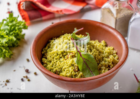Couscous in Schüssel mit Olivenöl und getrockneten Tomaten auf weißem Hintergrund, orientalische Küche, horizontale Ausrichtung Stockfoto