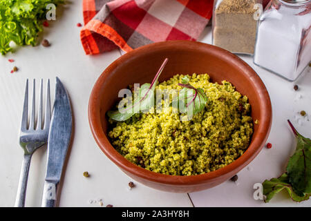 Couscous in Schüssel mit Olivenöl und getrockneten Tomaten auf weißem Hintergrund, orientalische Küche, horizontale Ausrichtung Stockfoto