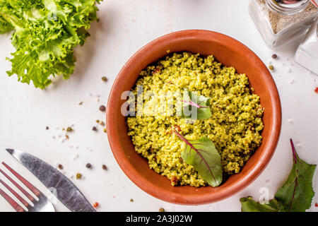 Couscous in Schüssel mit Olivenöl und getrockneten Tomaten auf weißem Hintergrund, orientalische Küche, horizontale Ausrichtung, Ansicht von oben Stockfoto