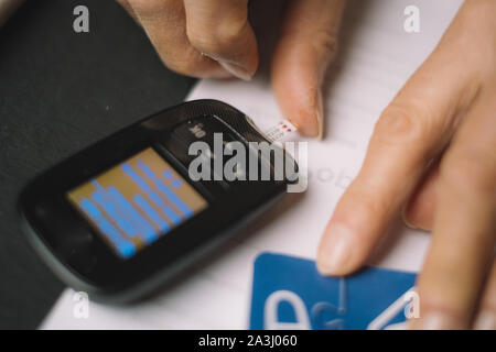 Eine Person seine eigenen Diabetes Werte prüfen Stockfoto