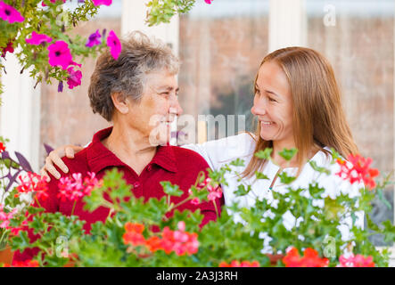 Gerne ältere Frau und ihre hilfreichen Assistenten Stockfoto