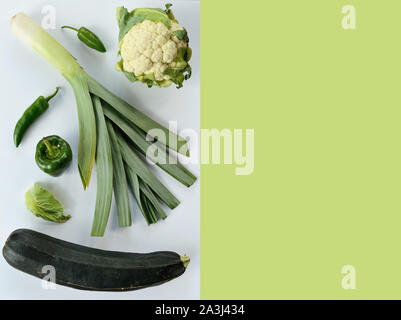 Kreative Gestaltung aus Zucchini Lauch Blumenkohl grüne und Chili. Flach. Essen Konzept. Grünes Gemüse isoliert auf weiß-grünen Hintergrund Stockfoto