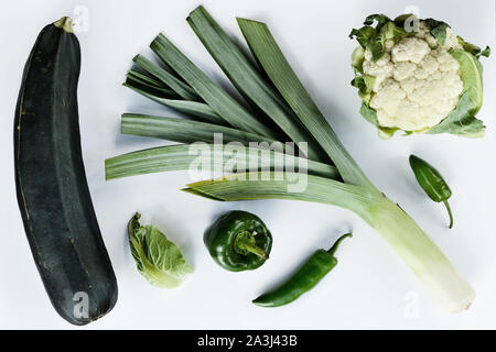 Kreative Gestaltung aus Zucchini Lauch Blumenkohl grüne und Chili. Flach. Essen Konzept. Grünes Gemüse auf weißem Hintergrund Stockfoto