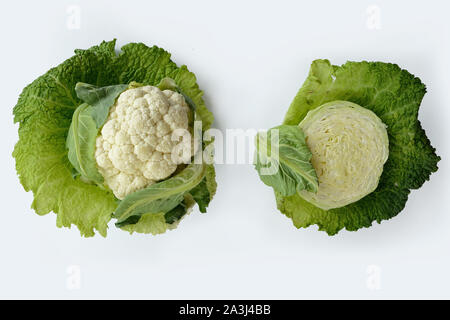 Zwei Köpfe von Kohl und Blumenkohl mit Blättern auf weißem Hintergrund. Kochen Konzept Stockfoto