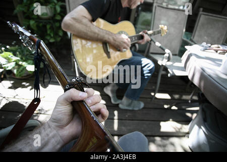 First Person Perspektive spielt Gitarre mit einer anderen Person. Stockfoto