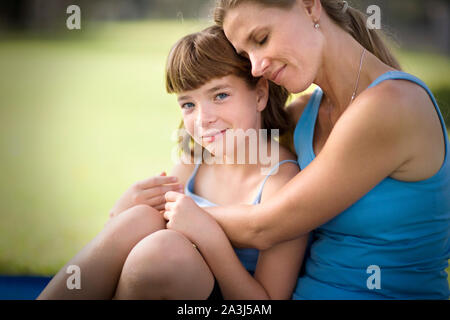 Porträt eines Mädchens, das von ihrem mittleren umarmte, - Erwachsene Mutter. Stockfoto