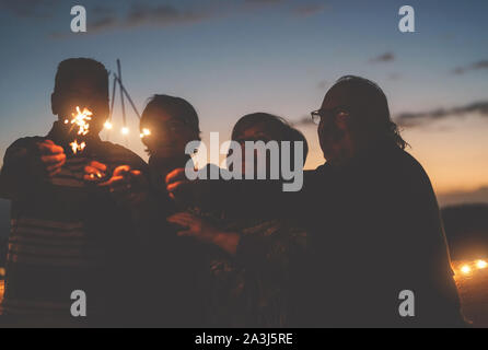 Gerne ältere Freunde feiern Geburtstag mit WUNDERKERZEN Sterne Outdoor - Ältere Menschen Spaß in Terrasse im Sommer Nächte Stockfoto