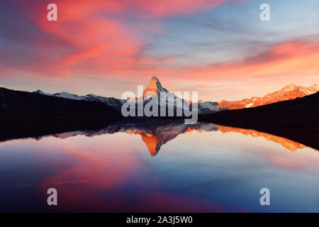 Herrliche Landschaft mit farbenfrohen Sonnenaufgang am Stellisee See. Snowy Matterhorn Matterhorn Gipfel mit Reflexion in klares Wasser. Zermatt, Schweizer Alpen Stockfoto