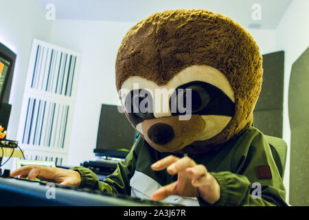 Lustiger Kerl in einem lemur Kostüm ist das Klavierspiel in seinem Studio Stockfoto