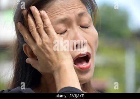 Eine müde Filipina Frau Stockfoto