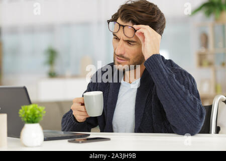 Dsabled Geschäftsmann auf Rollstuhl arbeiten Home Stockfoto