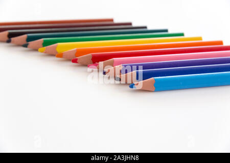 Selektiver Fokus Nahaufnahme von einer Reihe von bunten, dicken Buntstiften mit Spitzen im Vordergrund, auf weissem neutralen Hintergrund isoliert. Stockfoto