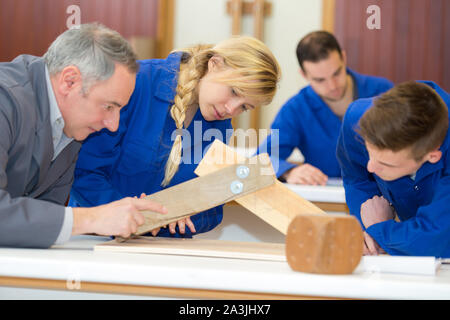 Junge weibliche Schreiner Messung von Holz in der Werkstatt Stockfoto